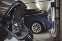 Close-up de tomada de combustível carro elétrico na garagem — Fotografia de Stock