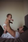 Padre che gioca con il bambino in camera da letto a casa — Foto stock