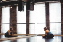 Молодая танцовщица выполняет упражнения на растяжку в танцевальной студии — стоковое фото