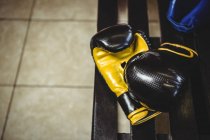 Крупный план боксерских перчаток на скамейке в раздевалке — стоковое фото