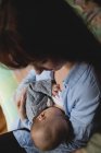 Крупним планом матері грудного вигодовування новонародженої дитини в спальні в домашніх умовах — стокове фото