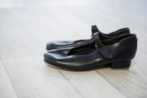 Primer plano de los zapatos de grifo en el suelo de madera - foto de stock