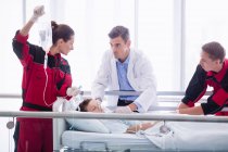 Лікарі вивчають пацієнта в коридорі в лікарні — стокове фото