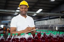 Портрет молодого працівника-чоловіка, який відзначає на заводі соків — стокове фото