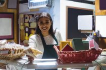 Lächelnde Kellnerin gibt Paket am Schalter im Café ab — Stockfoto