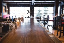 Interno di un bar vuoto con tavolo lungo — Foto stock