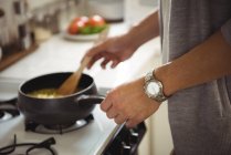 Средняя часть человека приготовления пищи на кухне в домашних условиях — стоковое фото