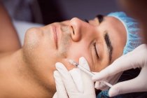 Homme recevant une injection de botox sur le visage à la clinique — Photo de stock