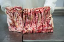 Мясник режет мясо на мясокомбинате — стоковое фото