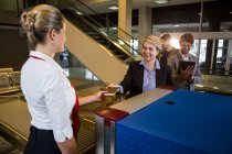 Businesswoman in queue receiving passport and boarding pass at airport terminal — Stock Photo