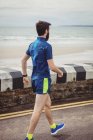 Спортсмен ходит по дороге рядом с пляжем — стоковое фото