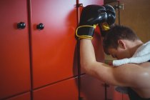 Depressed boxer posing after defeat in locker room — Stock Photo