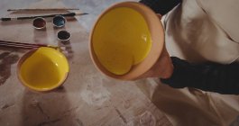 Поттер держит керамическую чашу в керамической мастерской — стоковое фото
