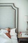 Senior mulher descansando na cama no quarto em casa — Fotografia de Stock