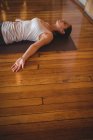 Woman performing yoga in fitness studio on wooden floor — Stock Photo