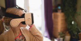 Ragazza seduta con auricolare realtà virtuale a casa — Foto stock