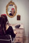 Жіночий перукар сидить у магазині дредлоків — стокове фото