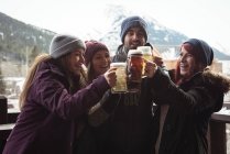Feliz amigos brindar com copos de cerveja no bar — Fotografia de Stock