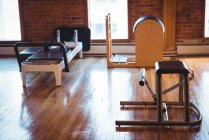 Reformador e equipamento desportivo em estúdio de fitness vazio — Fotografia de Stock