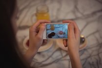 Primer plano de la mujer tomando la foto del desayuno con el teléfono móvil - foto de stock