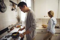 Paar bereitet zu Hause in der Küche Essen zu — Stockfoto