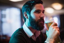 Gros plan de l'homme prenant un verre de bière dans un bar — Photo de stock