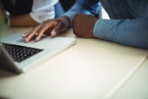 Бізнес-керівники використовують ноутбук в офісі, крупним планом — стокове фото