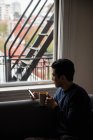 Man using mobile phone while having a cup of coffee at home — Stock Photo