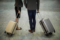 Low section of business people walking with luggage at airport terminal — Stock Photo