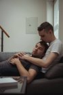 Романтическая гей-пара отдыхает на диване в гостиной дома — стоковое фото