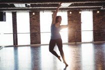 Young woman practicing modern dance in dance studio — Stock Photo