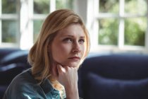 Close-up of thoughtful woman in living room at home — Stock Photo