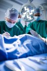 Група хірургів, що виконують операцію в операційному театрі лікарні — стокове фото