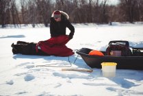 Pêcheur de glace assemblant tente dans un paysage enneigé — Photo de stock