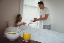 Breakfast and juice on kept on table in bedroom at home — Stock Photo