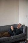 Людина прослуховування музики на мобільний телефон вдома — стокове фото