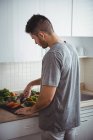 Mann legt zu Hause Paprika auf Burrito in die Küche — Stockfoto