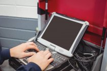 Руки жіночий механік, використовуючи ноутбук у ремонт гаража — стокове фото