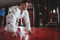 Karate player haciendo push-up en el gimnasio - foto de stock