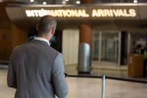 Rückansicht von Geschäftsmann mit digitalem Tablet im Wartebereich am Flughafen-Terminal — Stockfoto