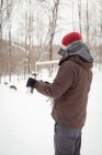 Musher derramando bebida quente de garrafa térmica durante o inverno — Fotografia de Stock