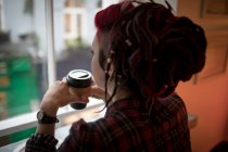 Mulher atenciosa tomando uma xícara de café no café — Fotografia de Stock