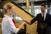 Жіночий персонал, даючи інтернат передати пасажира в аеропорту терміналу — стокове фото