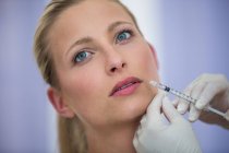Close-up of mid adult female patient receiving botox injection on face — Stock Photo