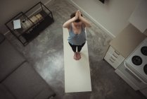 Vista ad alto angolo di donna che esegue yoga a casa — Foto stock