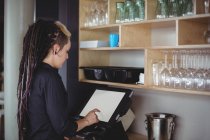 Waitress using cash register at counter in cafe — Stock Photo
