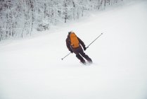 Uomo sciare giù per la montagna in una stazione sciistica — Foto stock