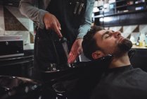 Man getting hair washed in barber shop — Stock Photo