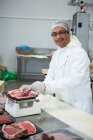 Macellaio che pesa carne su scala industriale — Foto stock