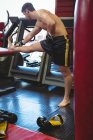 Boxer doing stretching exercise in fitness studio — Stock Photo